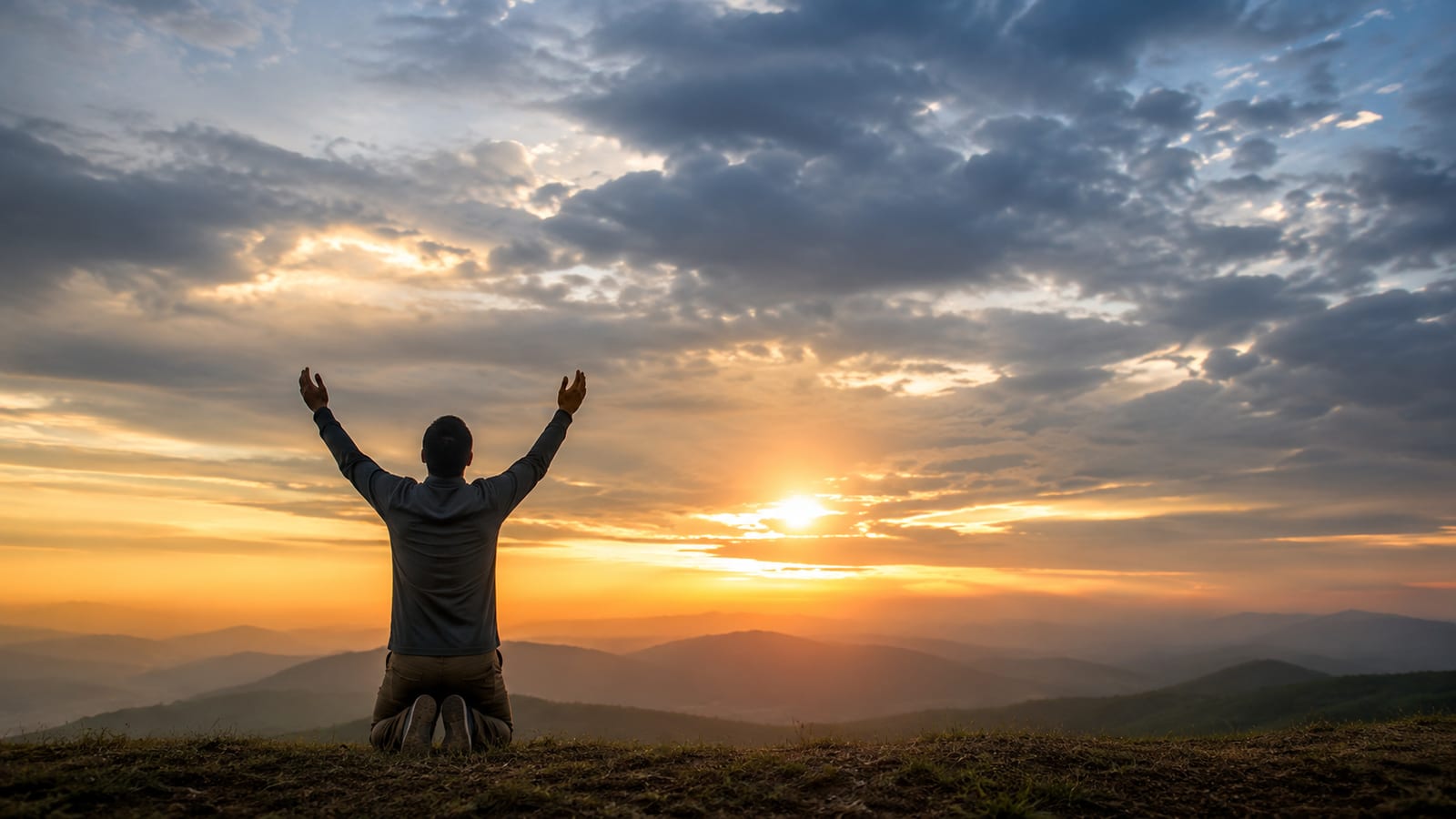Person praying at dawn beneath dramatic clouds, symbolizing biblical prophecy and spiritual reflection