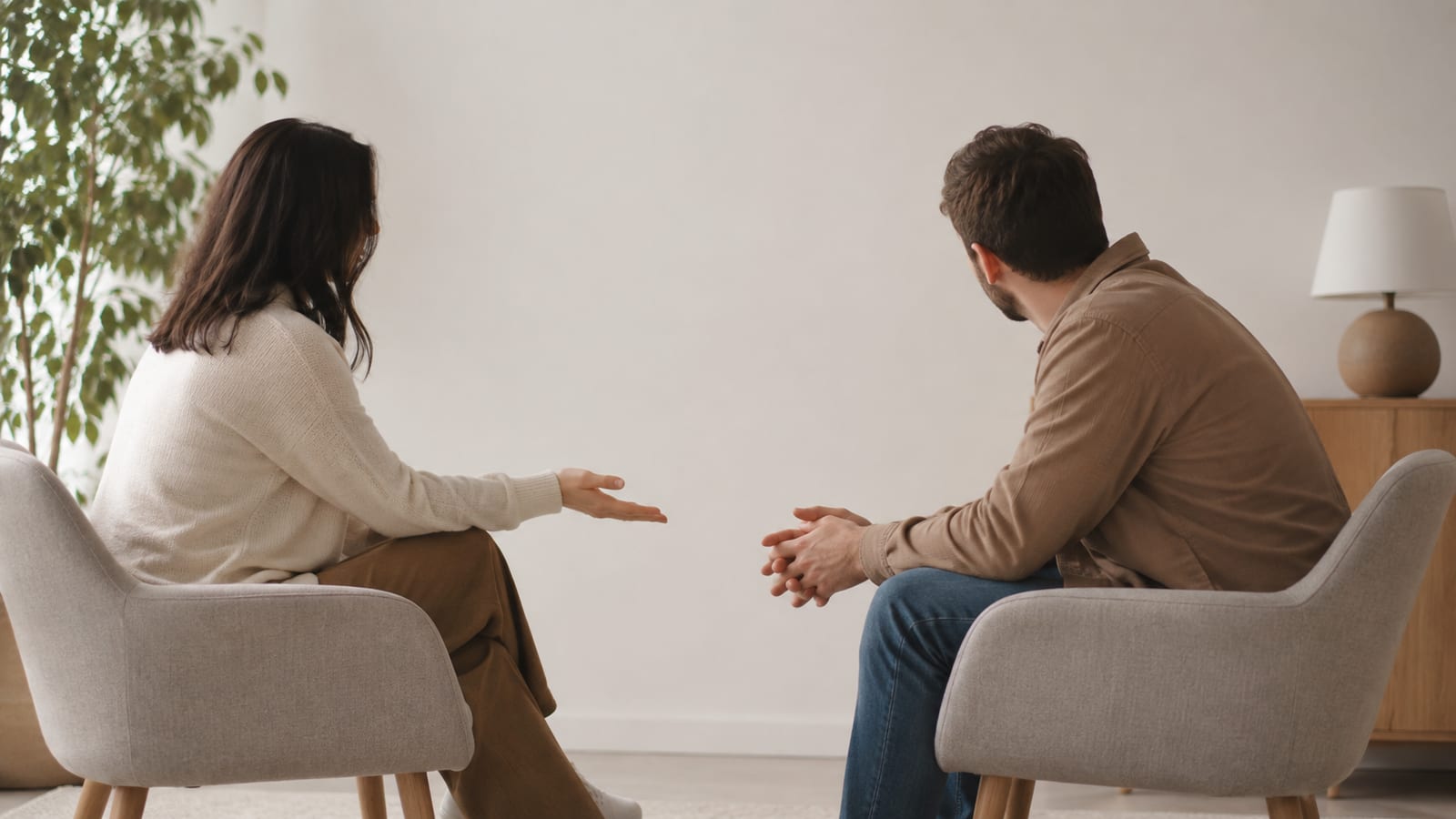 Two adults cautiously reaching toward a handshake while maintaining respectful distance in a quiet room